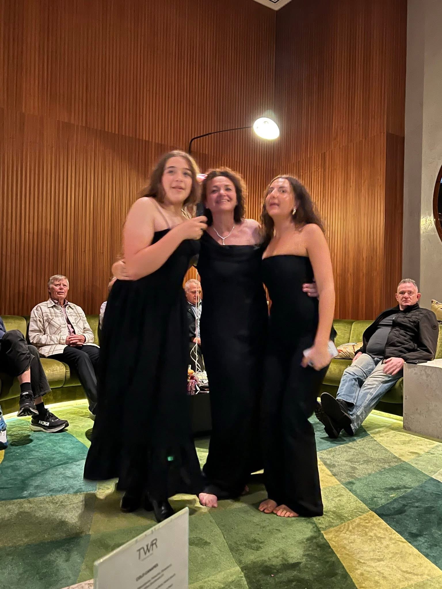 Three women dressed up at an event